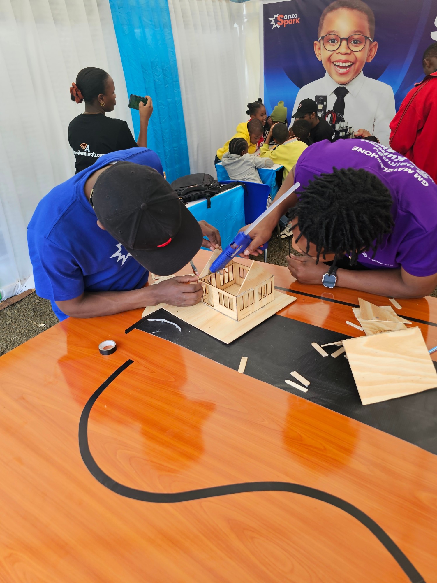 SonzaSpark team and students building a model at a Tanzanian exhibition