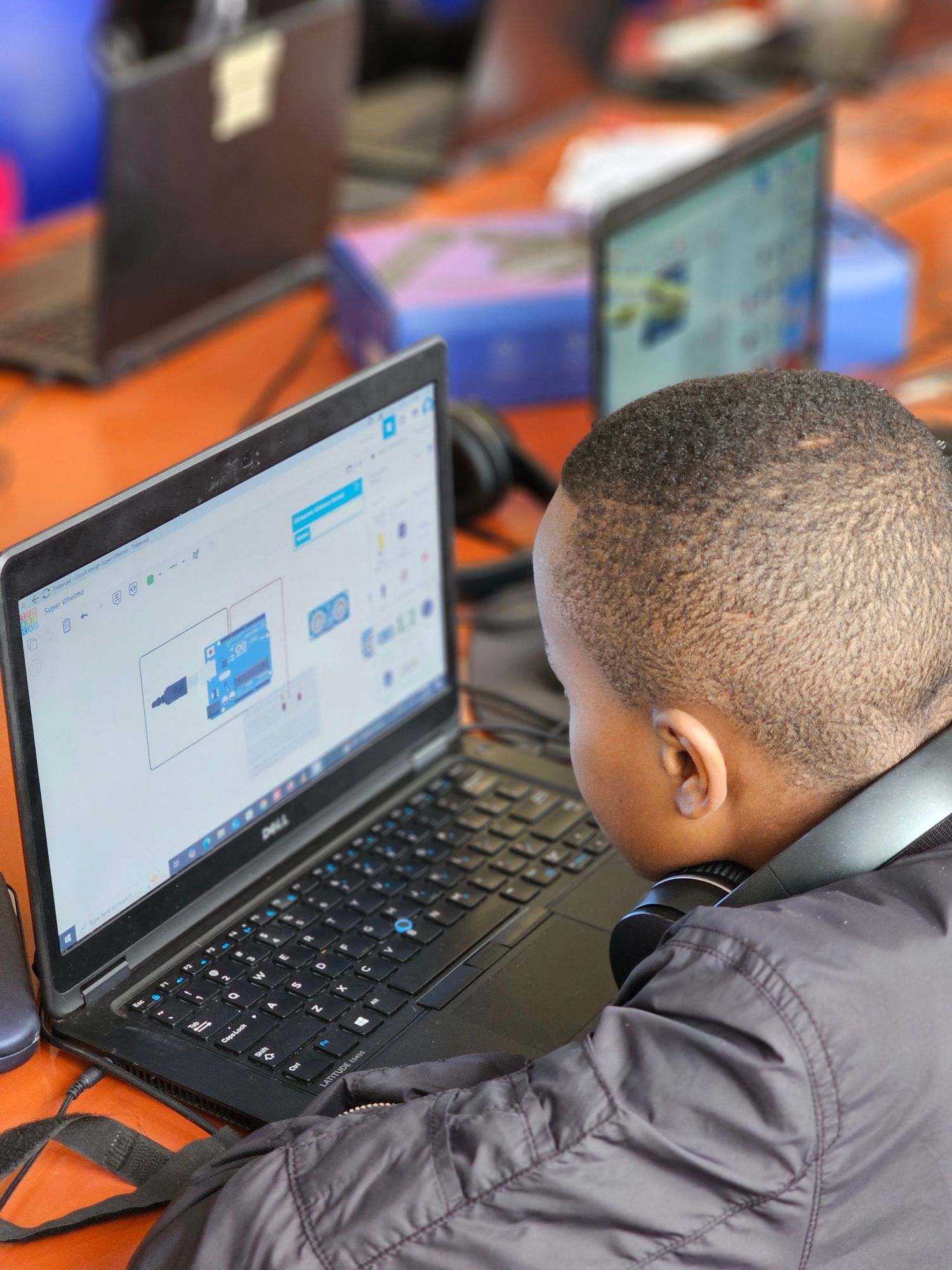 A young SonzaSpark student designing a circuit in Tinkercad on a laptop